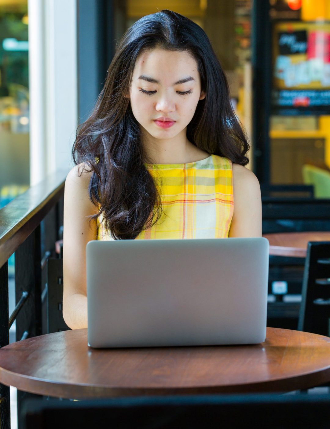 Asian woman happily using a notebook